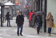 Pedestrians walk through the snow in Belfast City centre in Northern Ireland, on March 22, 2013